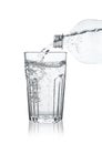 Pouring soda water from bottle into glass on white background Royalty Free Stock Photo