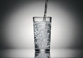 Pouring sparkling water in a glass on a dark background Royalty Free Stock Photo