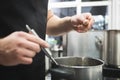 Pouring spices to the soup Royalty Free Stock Photo