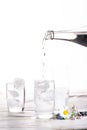 Pouring of stil mineral drink water in glasses with ice cubes cl Royalty Free Stock Photo