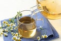 Pouring chamomile tea into cup on table Royalty Free Stock Photo