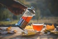 Pouring tea into a cup on the background of the sunset, with Royalty Free Stock Photo