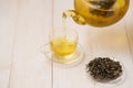 Pouring tea. Cup of hot tea and tea leaf on the wooden table Royalty Free Stock Photo