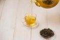 Pouring tea. Cup of hot tea and tea leaf on the wooden table Royalty Free Stock Photo