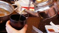 Pouring tea in a cup. A teapot and a cup of tea on the marble table at the restaurant. Royalty Free Stock Photo