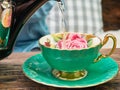 Pouring a tea into a green cup Royalty Free Stock Photo