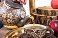 Pouring tea from kettle on old wooden table with fruit Royalty Free Stock Photo