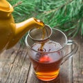 Pouring tea in glass cup, rustic wood background Royalty Free Stock Photo