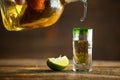 Pouring Tequila into shot glass. Selective focus. Blurred background.