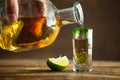 Pouring Tequila into shot glass. Selective focus. Blurred background.