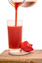 Pouring tomato juice in transparent glasses decorated vegetables isolated on white background Royalty Free Stock Photo