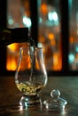 Pouring in tulip-shaped tasting glass Scotch single malt or blended whisky