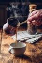 Pouring turkish coffee into white cup Royalty Free Stock Photo