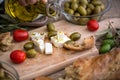 pouring virgin olive oil on vegetarian salad with fresh vegetables, feta cheese and green olives. Royalty Free Stock Photo