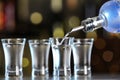 Pouring vodka from bottle into shot glass on counter Royalty Free Stock Photo