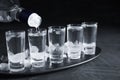 Pouring vodka from bottle into shot glass on table Royalty Free Stock Photo