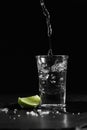 Pouring vodka into the shot glass on a black background with a blank space for a text Royalty Free Stock Photo