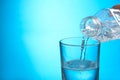 Pouring water from bottle into glass on background. Space for text Royalty Free Stock Photo