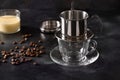 Pouring water in drip filter for cooking Vietnamese coffee with sweet condensed milk.