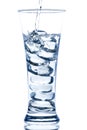 pouring water in an elegant tall glass with ice and water drops Royalty Free Stock Photo