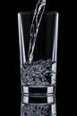 Pouring water into glass on black background Royalty Free Stock Photo