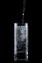 Pouring water into a glass on a black background Royalty Free Stock Photo