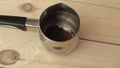 Pouring water into a jezva with freshly ground coffee