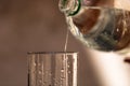 Pouring water from plastic bottle into a glass on blurred background. Selective focus and copy space Royalty Free Stock Photo