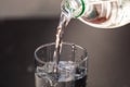 Pouring water from plastic bottle into a glass on blurred background. Selective focus and copy space Royalty Free Stock Photo