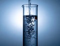 Pouring Water into a Tall Glass with Bubbles and Splash Effect Royalty Free Stock Photo