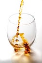 Pouring whiskey from bottle in to the glass without ice cubes on white table Royalty Free Stock Photo