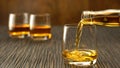 Pouring whiskey into the glass on a wooden table Royalty Free Stock Photo