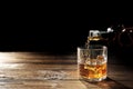 Pouring whisky into glass on wooden table Royalty Free Stock Photo