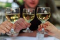 Pouring white wine into the glass against wooden table