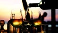 Pouring white wine in glass in slow motion at amazing sunset with sea view in a beach restaurant. Close up. 1920x1080