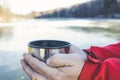 Pours hot tasty tea from a thermos in the winter into the cold.