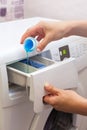 She pours the liquid powder in washing machine. Royalty Free Stock Photo