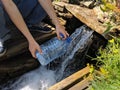 Pours water into a bottle from stream with clean drinking water