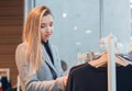 Pout girl choosing clothes in retail store