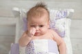 Pouting Baby Girl in Tiny Bed Royalty Free Stock Photo