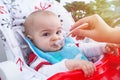 Pouting baby have lunch at the table in a suny day Royalty Free Stock Photo