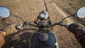 POV biking dirt road through wild autumn valley on vintage motorcycle Royalty Free Stock Photo