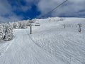 POV: Chairlift ride over vast ski resort slopes covered in pristine crud snow. Royalty Free Stock Photo