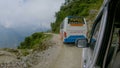 POV: Driving behind a tourist bus and along a bumpy dirt road in rural Nepal.