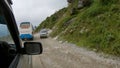 POV: Driving behind a tourist bus as you pass a jeep travelling across Nepal