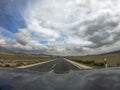 Pov driving a car on asphalt road in Andalusia.A power line cross the lane Royalty Free Stock Photo