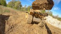 POV: Excavator arm scoops up a bucket full of soil and unloads it on trailer. Royalty Free Stock Photo