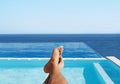 POV, feet and man relax at a pool for travel and summer vacation at the sea by hotel and water. Barefoot, calm and