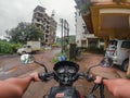 POV of guy riding a motorcycle on a village road with construction works in the background. Royalty Free Stock Photo