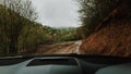 POV inside car windshield view point. Driver driving a modern off road right hand drive RHD car on the mountain forest dirty Royalty Free Stock Photo